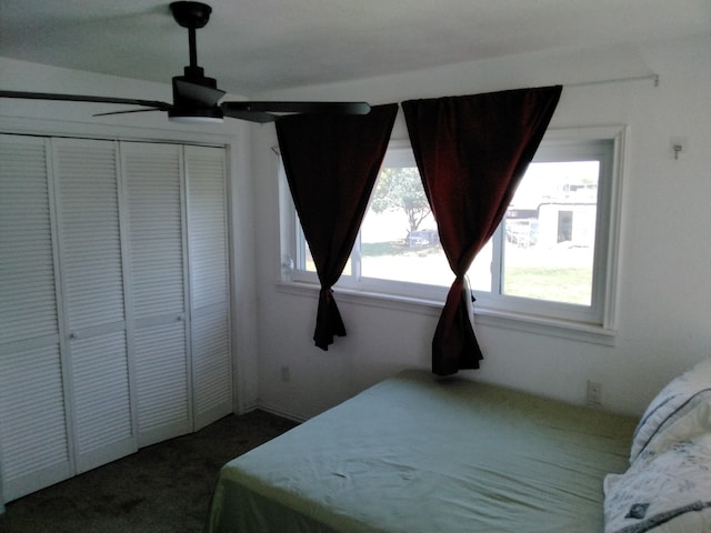 bedroom with a closet, dark carpet, and ceiling fan