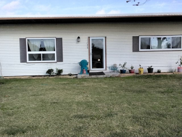 rear view of property featuring a lawn