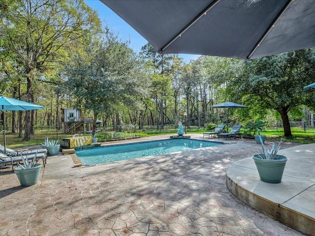 pool with a patio area and fence