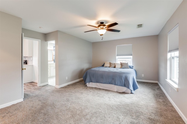 carpeted bedroom featuring connected bathroom and ceiling fan