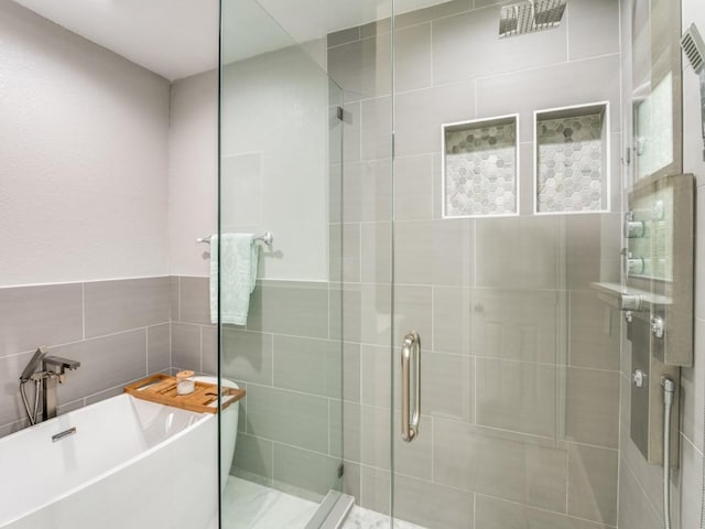 bathroom with plus walk in shower and tile walls