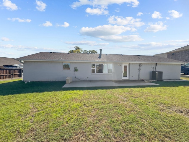 back of property with a patio area, a yard, and central AC