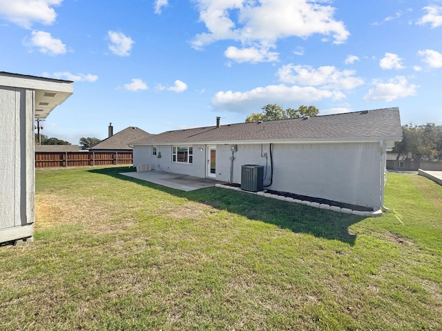 back of house featuring a lawn, a patio area, and central AC