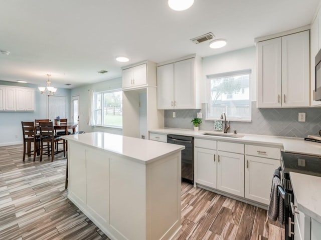 kitchen featuring dishwasher, white cabinetry, and sink