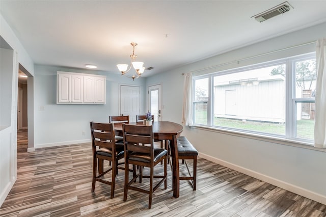 dining room featuring a notable chandelier, light wood-type flooring, and plenty of natural light