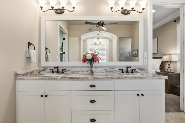 bathroom with vanity, ceiling fan with notable chandelier, and ornamental molding