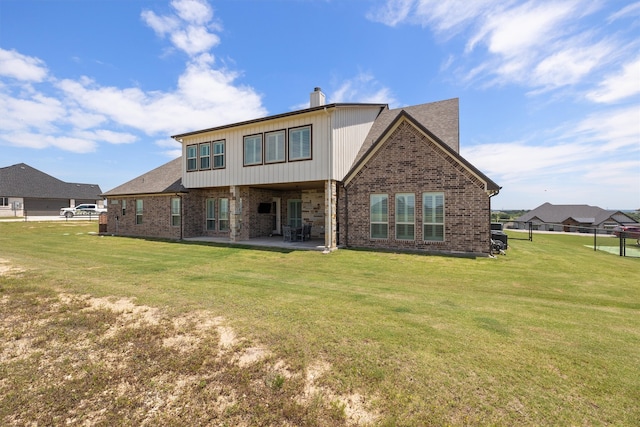 back of property featuring a lawn and a patio