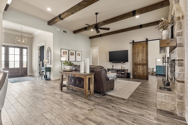 living room with hardwood / wood-style flooring, a barn door, and beamed ceiling