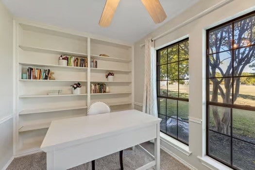 office space featuring built in features, ceiling fan, and carpet flooring