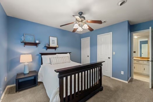 carpeted bedroom featuring ensuite bath and ceiling fan