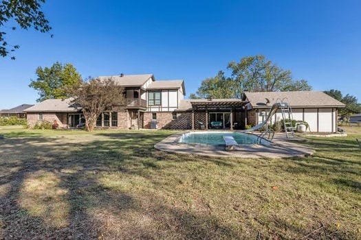 rear view of house featuring a yard and a pergola