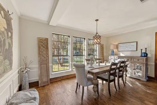 dining area with ornamental molding, dark hardwood / wood-style floors, and beamed ceiling