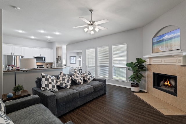 living room with ceiling fan, a fireplace, and dark hardwood / wood-style floors