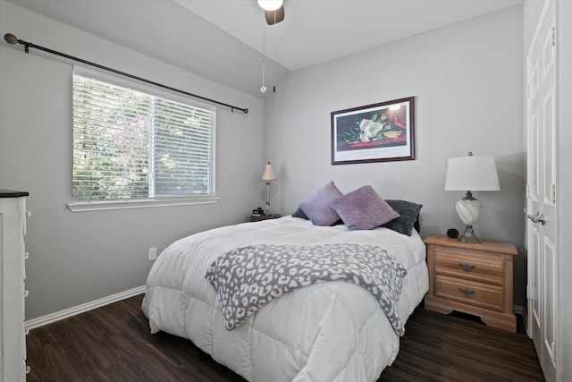 bedroom featuring dark hardwood / wood-style flooring, vaulted ceiling, and ceiling fan