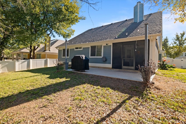 rear view of house with a sunroom, a patio area, and a yard