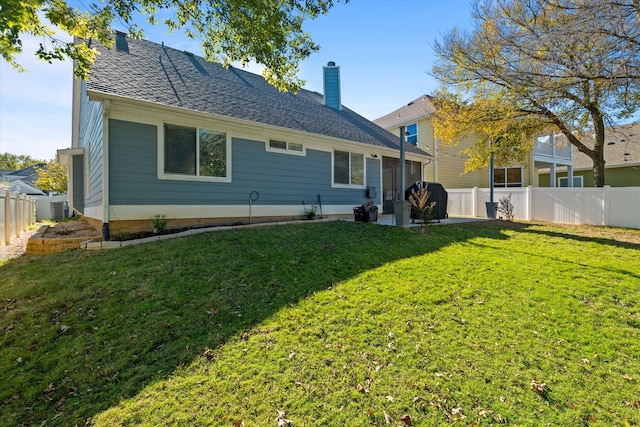 back of property featuring a yard and central air condition unit