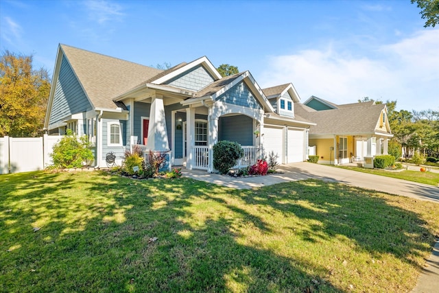 craftsman house featuring covered porch, a front yard, and a garage