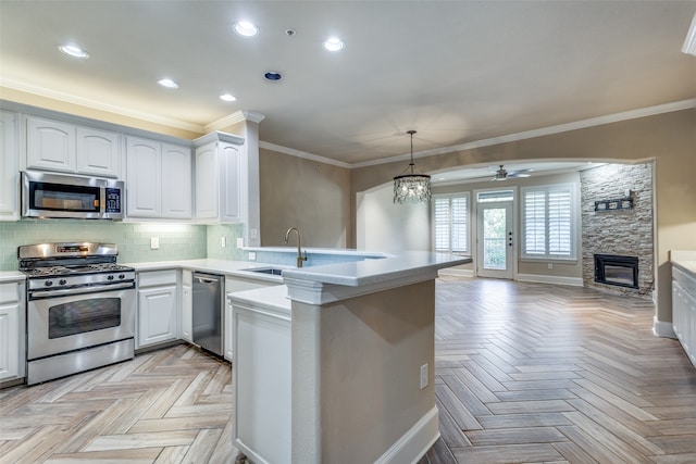 kitchen with white cabinetry, sink, kitchen peninsula, and stainless steel appliances