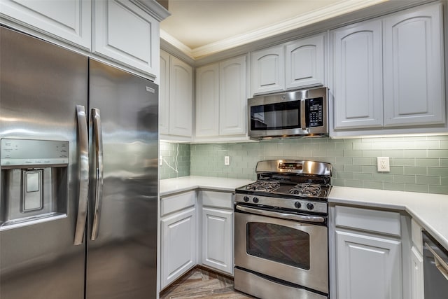 kitchen featuring decorative backsplash, white cabinetry, ornamental molding, and stainless steel appliances