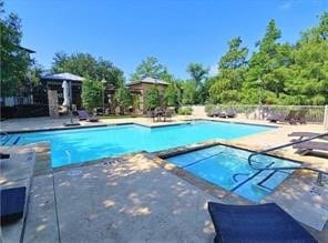 view of swimming pool featuring a patio area and an in ground hot tub