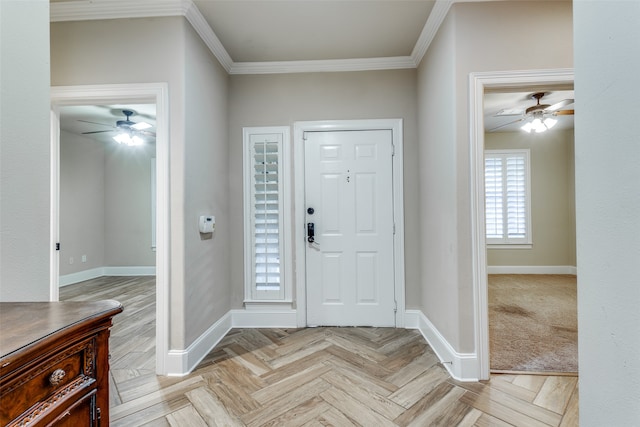 foyer entrance with light parquet flooring and crown molding