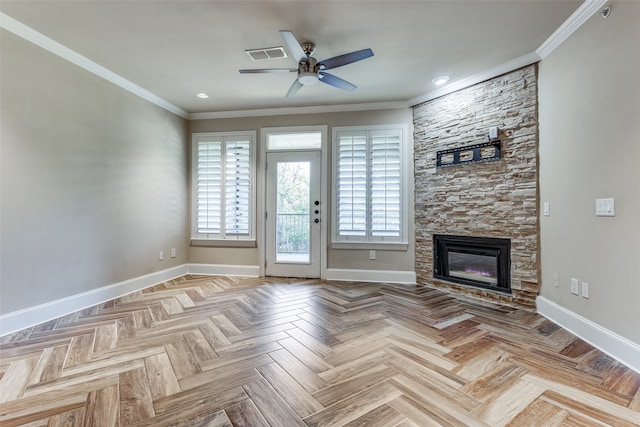 unfurnished living room with light parquet flooring, a stone fireplace, ceiling fan, and crown molding