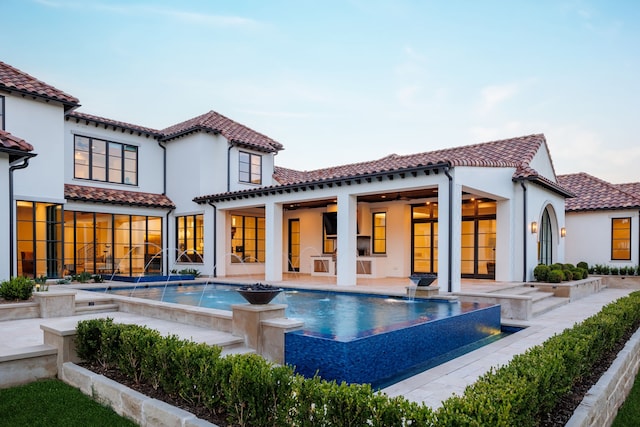 back of property featuring pool water feature, ceiling fan, and a patio area