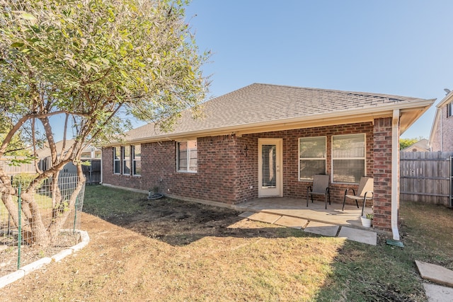 back of property featuring a patio area and a yard