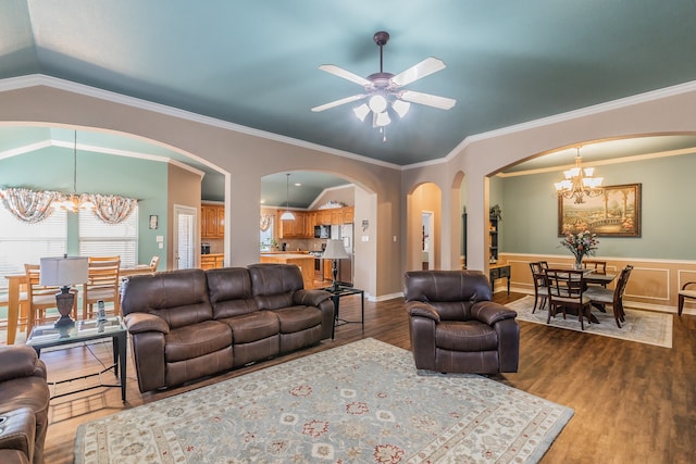 living room featuring ceiling fan with notable chandelier, wood-type flooring, ornamental molding, and lofted ceiling