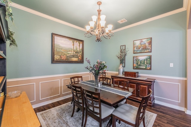 dining space with ornamental molding, dark wood-type flooring, and an inviting chandelier