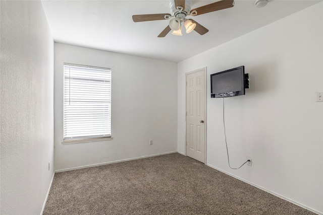 carpeted empty room featuring ceiling fan