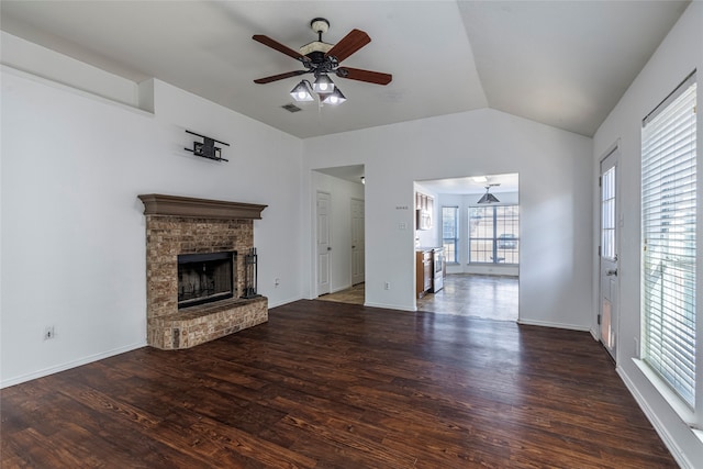 unfurnished living room with a fireplace, lofted ceiling, ceiling fan, and dark wood-type flooring