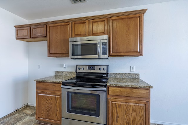 kitchen with light stone countertops and appliances with stainless steel finishes