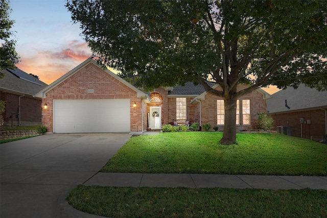 single story home with a garage, a yard, and central air condition unit