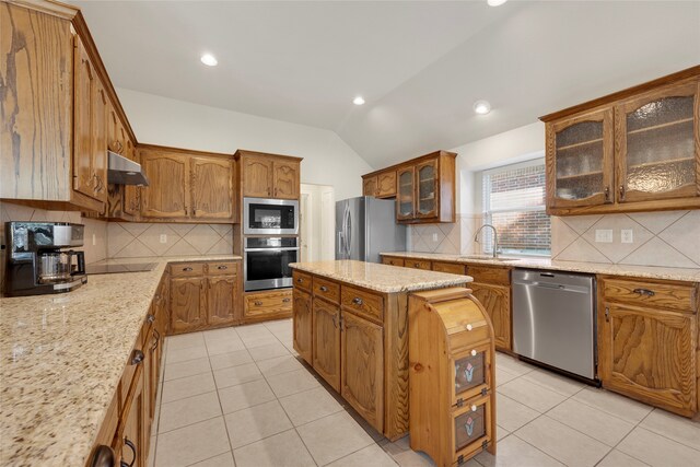 kitchen with sink, stainless steel appliances, light stone counters, lofted ceiling, and light tile patterned floors