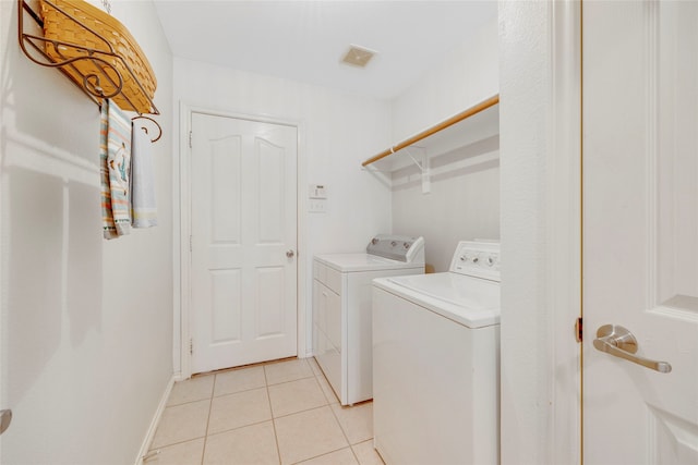 washroom featuring washing machine and dryer and light tile patterned floors