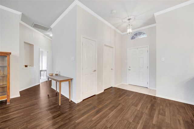 entrance foyer featuring crown molding, a towering ceiling, and dark wood-type flooring