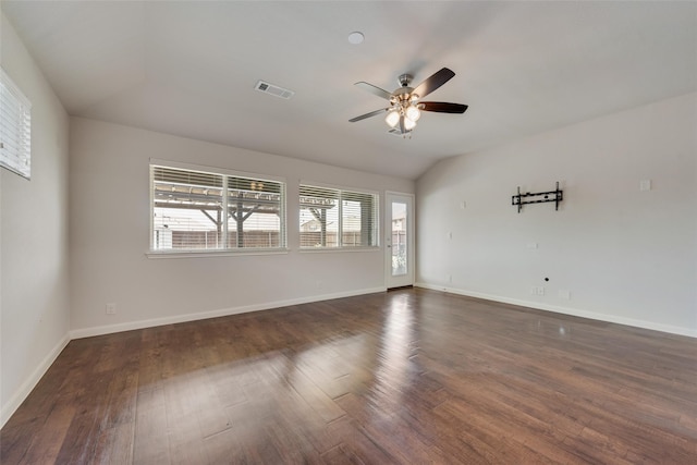 empty room featuring dark hardwood / wood-style flooring, vaulted ceiling, and ceiling fan