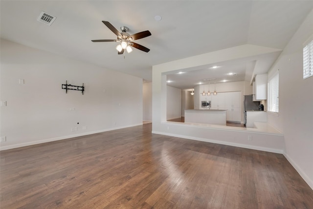 unfurnished living room with dark hardwood / wood-style flooring and ceiling fan