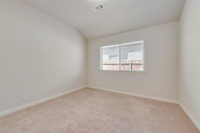 carpeted spare room with lofted ceiling