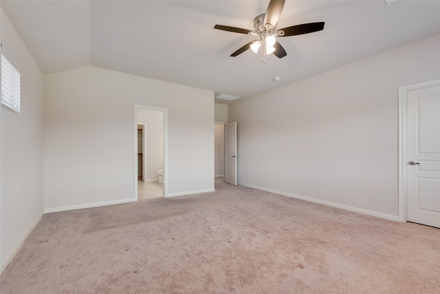 unfurnished bedroom with connected bathroom, ceiling fan, light colored carpet, and vaulted ceiling