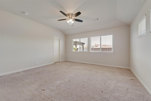 spare room with ceiling fan, lofted ceiling, and light carpet