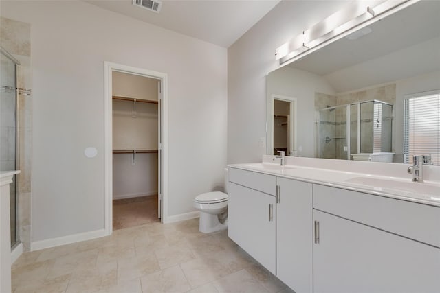 bathroom with vanity, vaulted ceiling, a shower with door, tile patterned flooring, and toilet