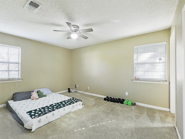 bedroom featuring a textured ceiling, carpet floors, and ceiling fan