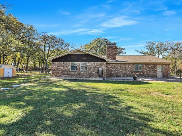 view of front of home featuring a shed and a front lawn