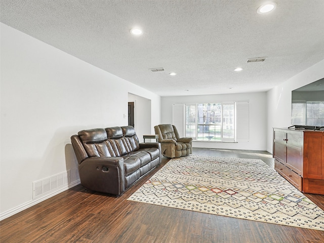 living room featuring dark hardwood / wood-style flooring and a textured ceiling