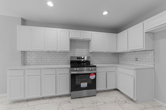 kitchen featuring white cabinetry, stainless steel stove, and tasteful backsplash