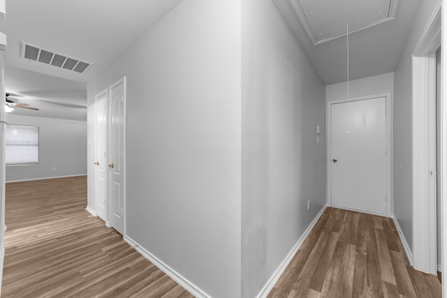 corridor with hardwood / wood-style flooring