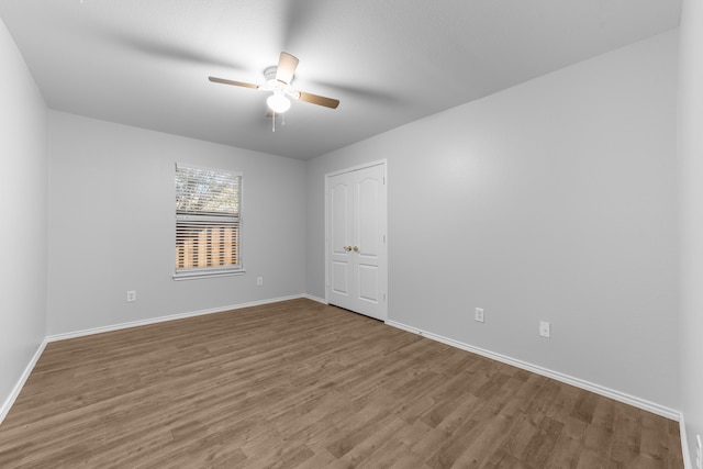 empty room with ceiling fan and wood-type flooring