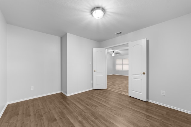 unfurnished bedroom with wood-type flooring and a textured ceiling